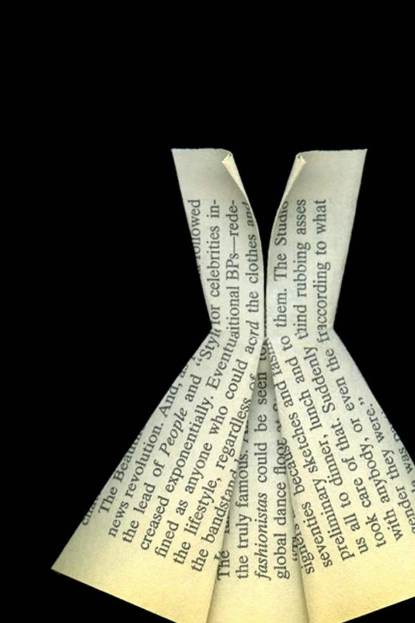 Folded pages of a book create the shape of a dress, set against a black background, symbolizing fashion and literature