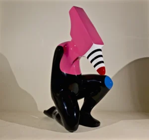 A pink and black sculpture featuring a stylish black hat atop its head.