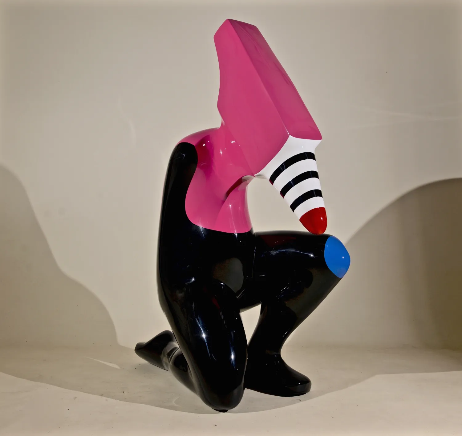 A pink and black sculpture featuring a stylish black hat atop its head.<br />