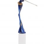 A blue and white sculpture depicting a woman gracefully holding a golf club.