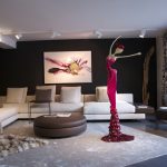 A spacious living room featuring a large sofa and an oversized painting on the wall.